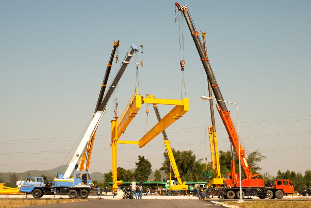 cranes lifiting huge industrial equipment part - Safety and Precision: The Cornerstones of Professional Crane Services