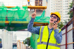 worker guiding crane operator during rigging operation - effective communication protocols between crane operators and riggers