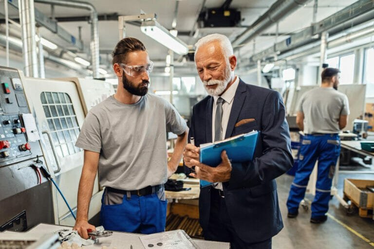 Worker discussing maintenance plan with professional - Maximizing Uptime using Industrial Maintenance Consulting