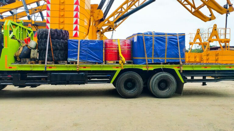 Truck loaded with heavy industrial machinery - securing heavy machinery for transport a comprehensive guide by alltracon
