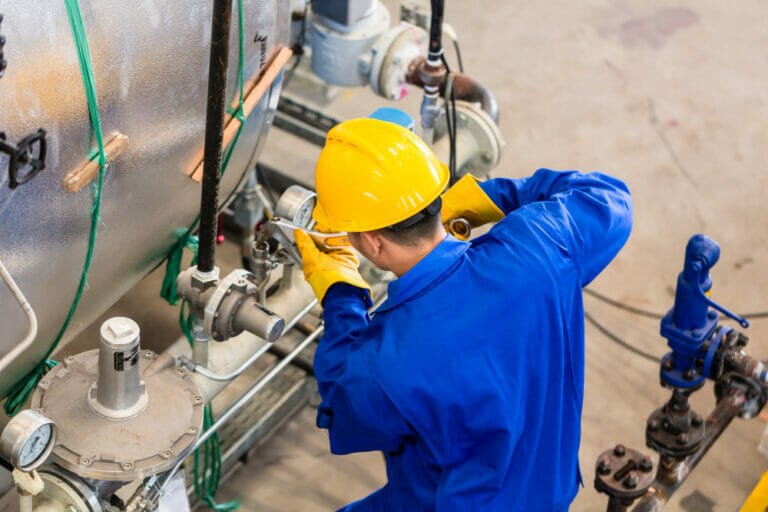 worker fixing hydarulic issues with machine - common hydraulic system issues and how professional repairs can help