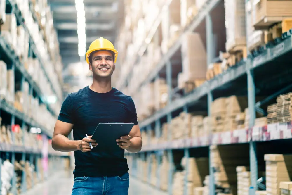 man doing warehouse management using tablet - risk management in warehousing how industrial services mitigate challenges