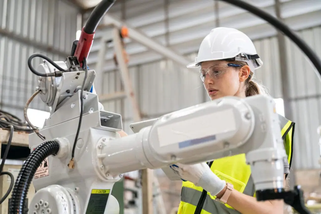 woman installing indudtrial robot - Industrial Plant Installation Best Practices for Safety and Efficiency